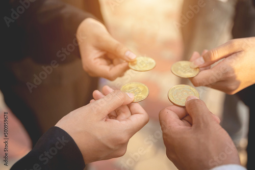 hand of a businessman holding bitcoins and solve puzzles together A business team assembles a bitcoin puzzle, a business group that wants to collect puzzle pieces.