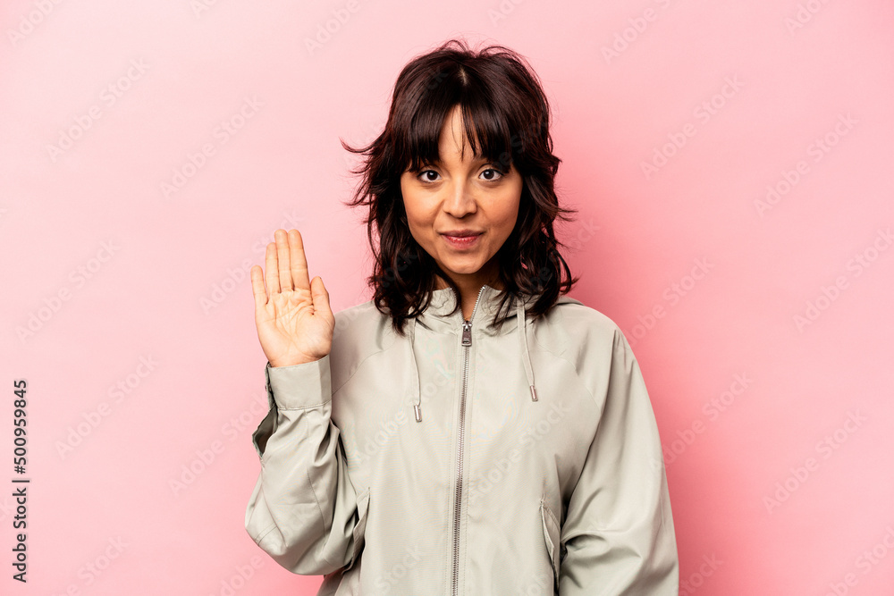 Young hispanic woman isolated on pink background smiling cheerful showing number five with fingers. Young hispanic woman isolated on pink background smiling cheerful showing number five with fingers.