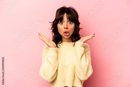 Young hispanic woman isolated on pink background surprised and shocked.