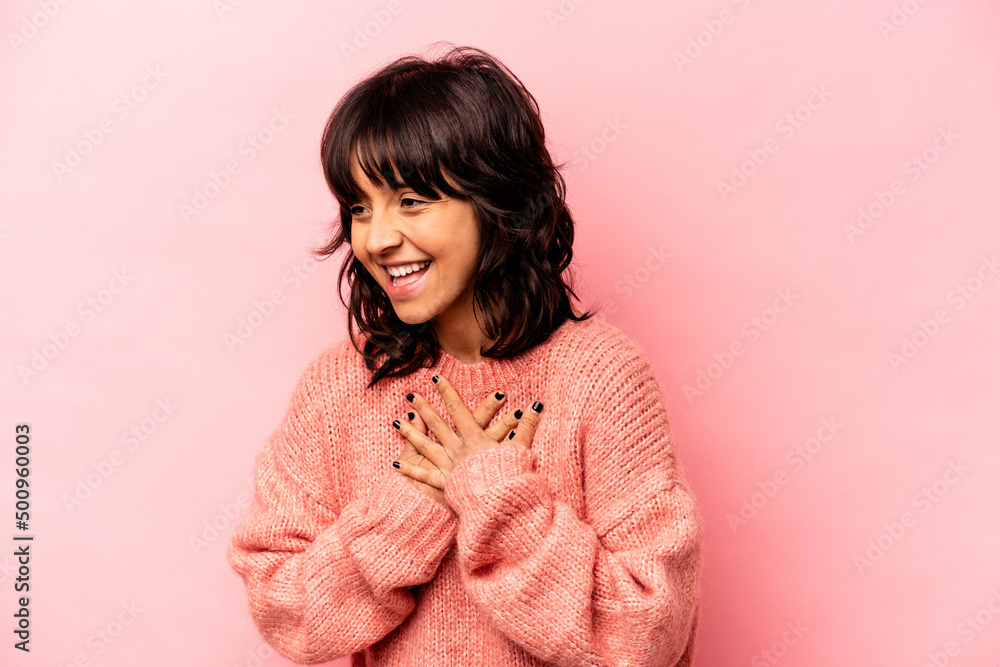 Young hispanic woman isolated on pink background laughing keeping hands on heart, concept of happiness. Young hispanic woman isolated on pink background laughing keeping hands on heart, concept of happiness.