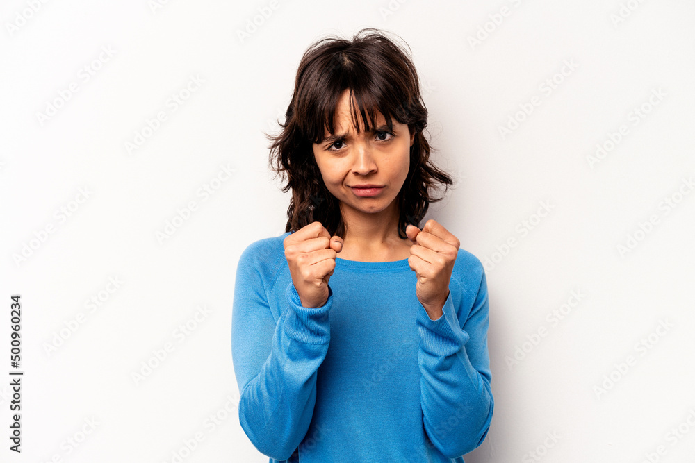 Young hispanic woman isolated on white background showing fist to camera, aggressive facial expression. Young hispanic woman isolated on white background showing fist to camera, aggressive facial expression.