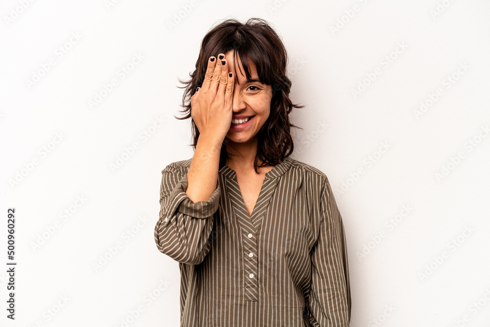 Young hispanic woman isolated on white background having fun covering half of face with palm. Young hispanic woman isolated on white background having fun covering half of face with palm.