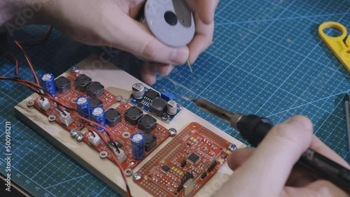 Soldering is done on the microchips in the factory with a soldering machine. electronic working hands.