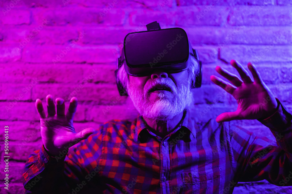 Obraz premium Asian senior man having fun using futuristic 3d goggles - Concept of technology
