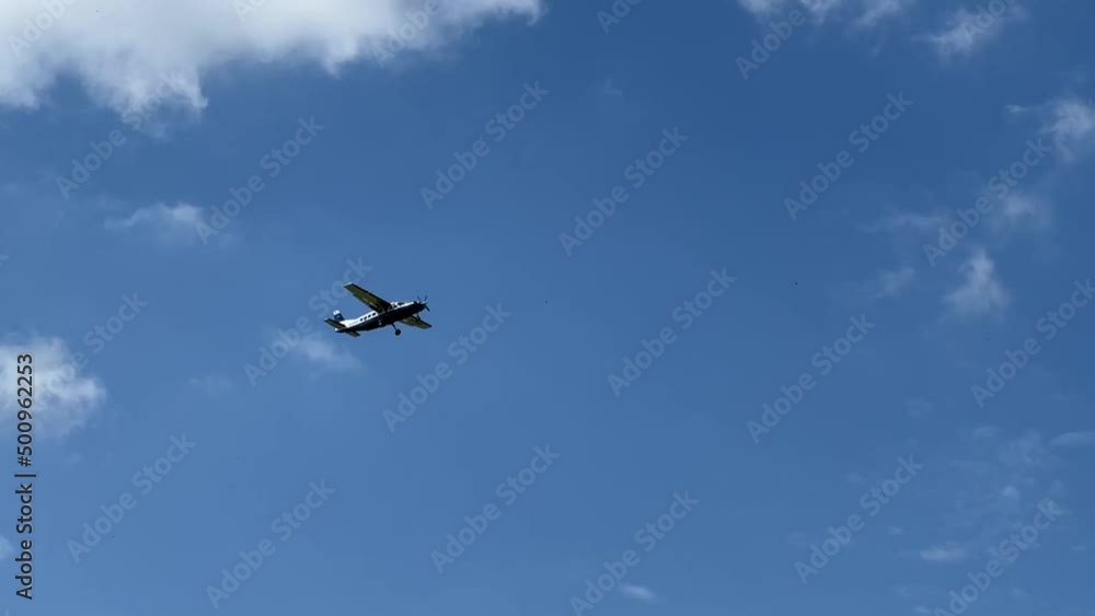 Cessna 208b Grand Caravan G-CPSS light aircraft ascending from take off in a blue sky white cloud on a flight to drop parachutists Cessna 208b Grand Caravan G-CPSS light aircraft ascending from take off in a blue sky white cloud on a flight to drop parachutists