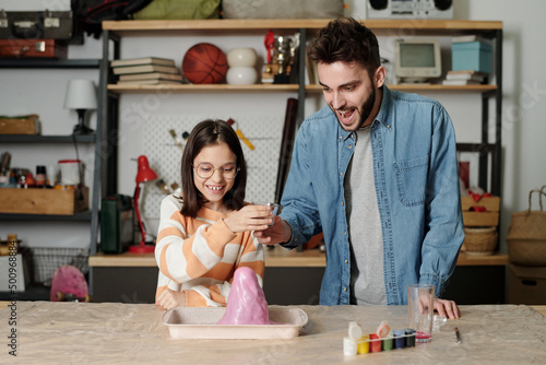 Cuadro en lienzo Cute little girl and her father looking at chemical reaction in handmade volcano