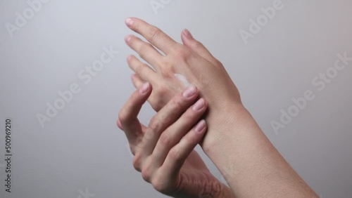Woman applying a cream on her hands to moistures a skin