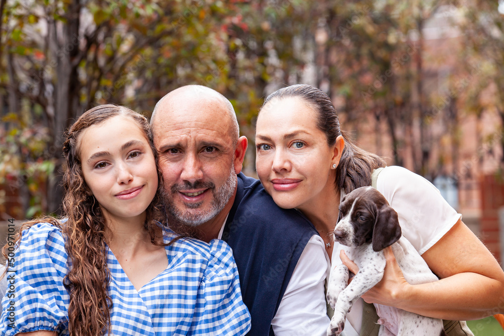 Young family outdoors with their newborn puppies in a sunny day Young family outdoors with their newborn puppies in a sunny day