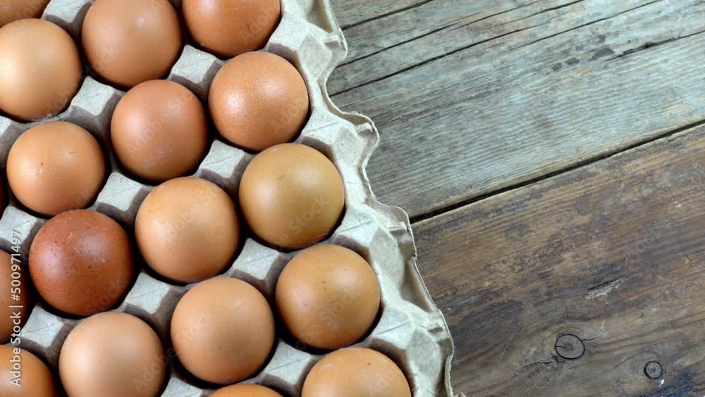 Egg background. Brown eggs top view in a paper box tray. Protein food. Packing chicken eggs on the farm. Eco organic. Egg background. Brown eggs top view in a paper box tray. Protein food. Packing chicken eggs on the farm. Eco organic.