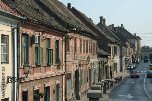 Serbia - Novi Sad - Old houses under tile roofs and with lamps on facades along Belgrade (Beogradska) street towards Petrovardin fortress gate photo