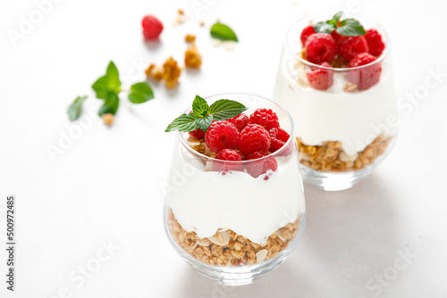 Granola with white plain yogurt and raspberry in a glass