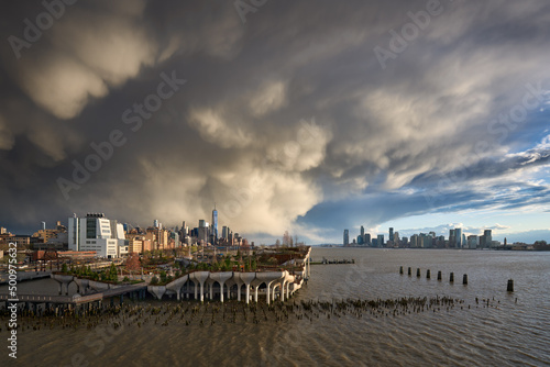 Passing storms over Manhattan at sunset along Hudson River Park. Views on West Village, World Trade Center and Downtown Jersey City. New York City, USA photo