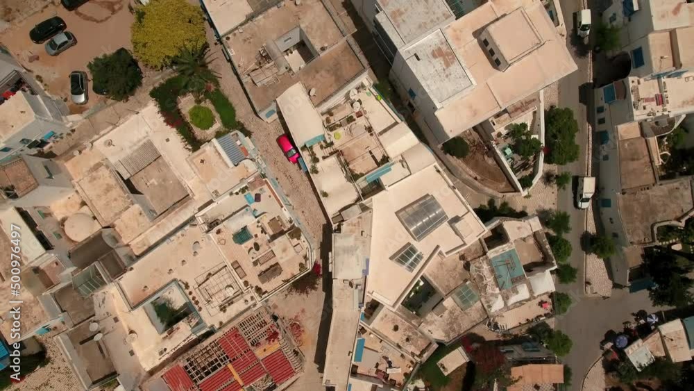 Aerial Forward Tilt Up Shot Of Residential Buildings In Town On Hill By Sea During Sunny Day - Djerba, Tunisia Aerial Forward Tilt Up Shot Of Residential Buildings In Town On Hill By Sea During Sunny Day - Djerba, Tunisia