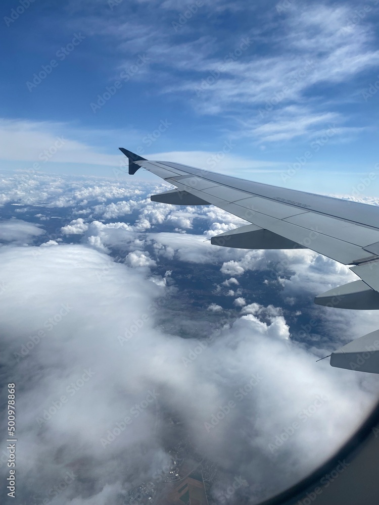 Obraz premium View out of airplane window - Blick aus dem Flugzeug auf Wolken von oben und die Tragfläche eines Airbus