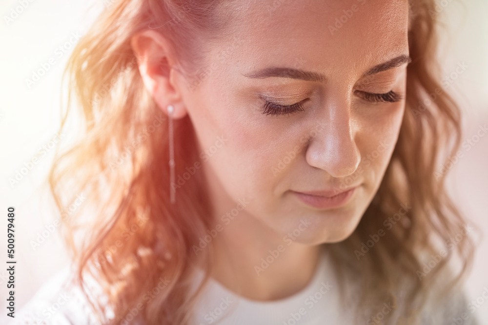 Lovely woman looking down. Beautiful model on the background of the sun's rays. Toning Lovely woman looking down. Beautiful model on the background of the sun's rays. Toning
