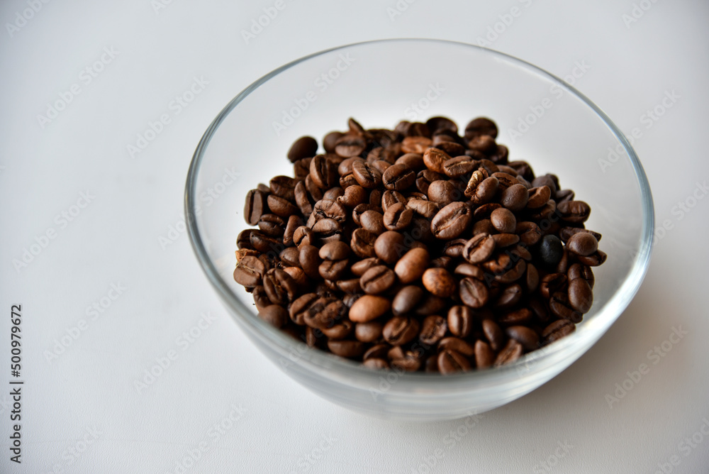Coffee beans in a glass bowl on a white background Coffee beans in a glass bowl on a white background