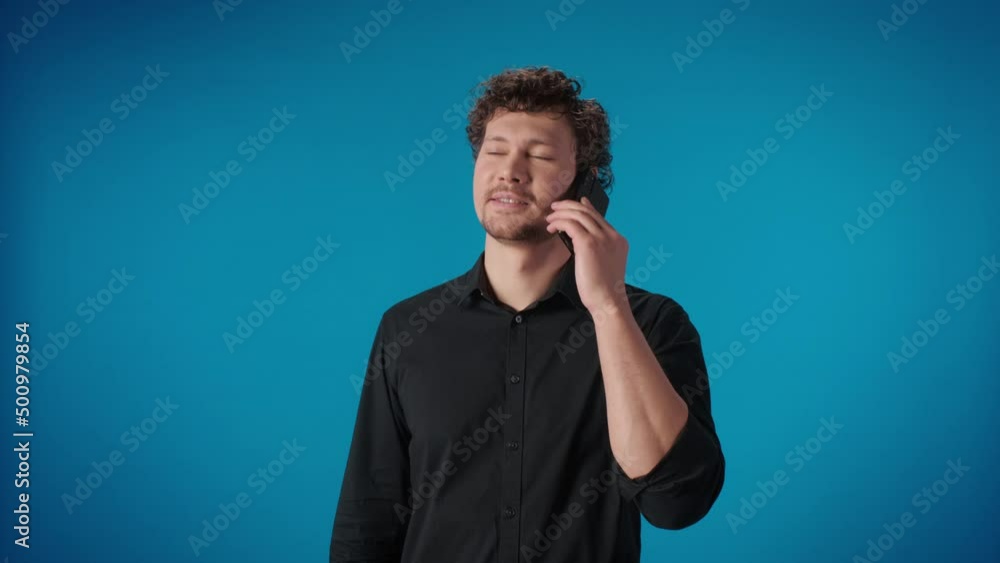 Portrait happy curly modern man call mobile phone enjoy friendly remotely communication posing Portrait happy curly modern man call mobile phone enjoy friendly remotely communication posing