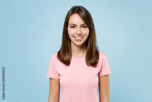 Young smiling cheerful fun cool happy european caucasian woman 20s wearing pink t-shirt looking camera isolated on pastel plain light blue color background studio portrait. People lifestyle concept.