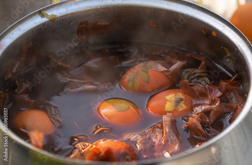 Die Eier werden dekoriert und in Zwiebelwasser gekocht damit sie schöne eingefärbt werden photo