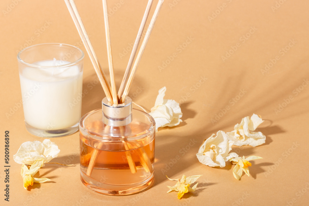 reed diffuser with flowers. Incense sticks for the home with a floral scent with hard shadows. The concept of eco-friendly fragrance for the home - obrazy, fototapety, plakaty 