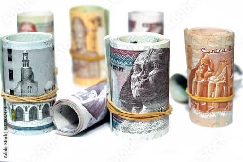 Egypt money roll pounds banknotes isolated on white background, Egyptian pounds cash money bills rolled up with rubber bands of 200 LE, 100, 50, 20, 10, 5, 1 pound and 50 piasters, selective focus photo