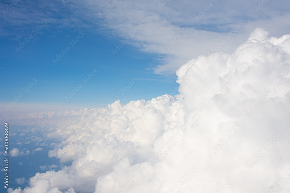 Fototapeta premium Wall of cumulus white fluffy clouds in the summer sky, unstable troposphere thunderstorm harbinger turbulence.