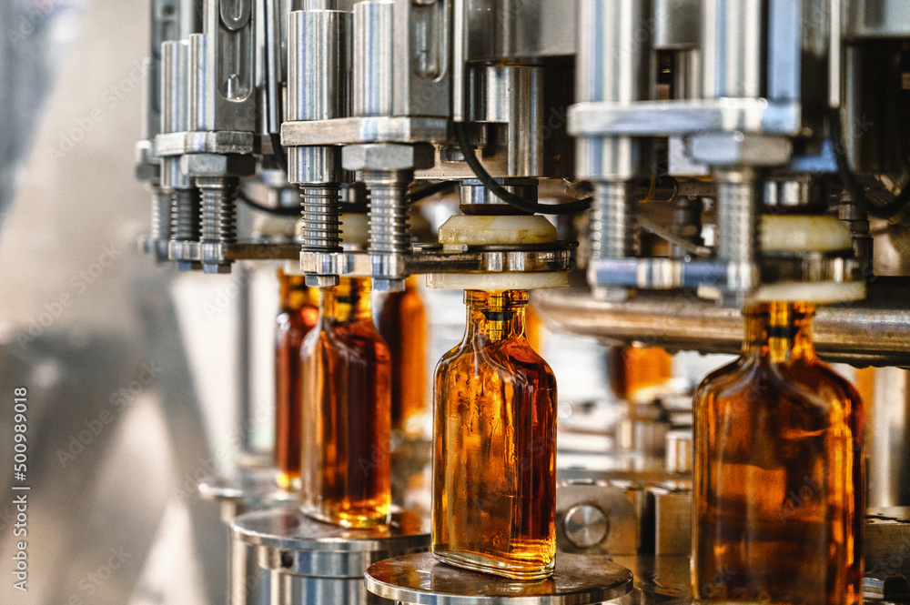 Conveyor carries glass bottles of luxury cognac in workshop Conveyor carries glass bottles of luxury cognac in workshop