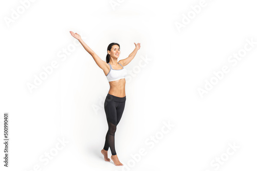 a girl in sportswear stands with her hands raised up, isolated on a white background photo