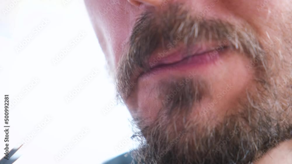 Close-up portrait of young guy puts pickled mushroom in mouth and chews with pleasure. Man eats wild mushrooms. Close-up portrait of young guy puts pickled mushroom in mouth and chews with pleasure. Man eats wild mushrooms.