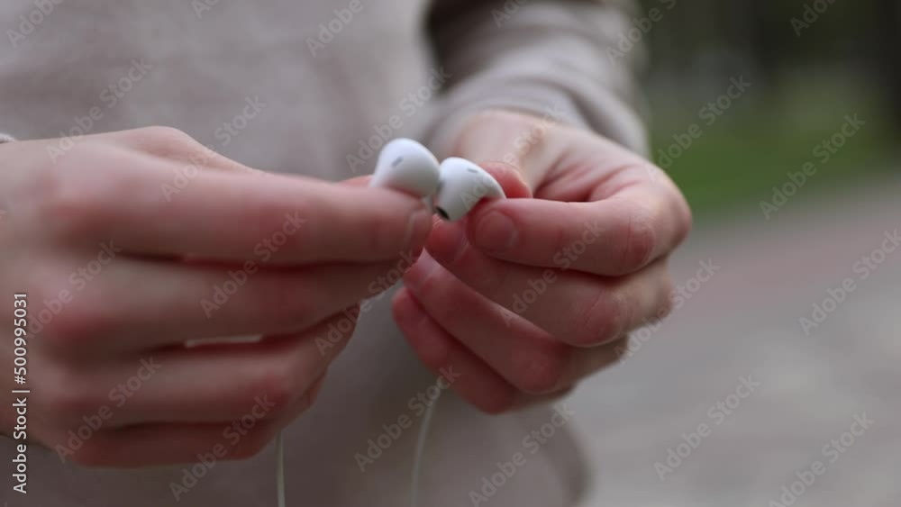 close-up male hands holding white headphones in the city close-up male hands holding white headphones in the city