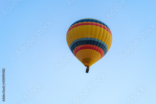 Colorful balloon flying over Cappadocia with a clear cloudless sky, copy space © MARIO MONTERO ARROYO