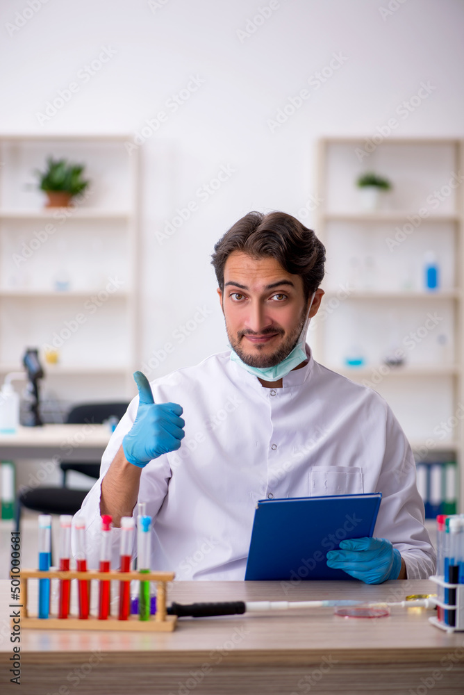 Young male chemist working at the lab Young male chemist working at the lab