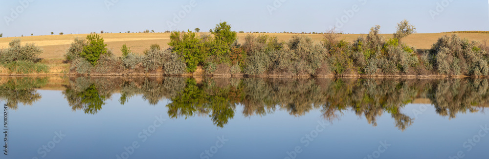Landscape with trees, reflecting in the water. Landscape with trees, reflecting in the water.