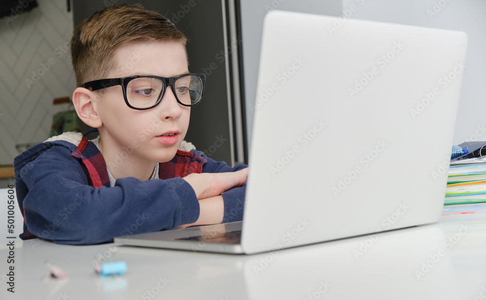 Boy doing homework on laptop
