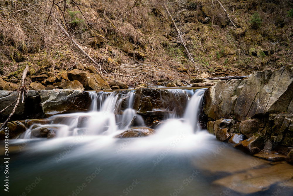 Mountain stream in spring in the stony forest. Beautiful river flowing by the forest during the Spring. Carpathian, Ukraine spring forest creek Mountain stream in spring in the stony forest. Beautiful river flowing by the forest during the Spring. Carpathian, Ukraine spring forest creek