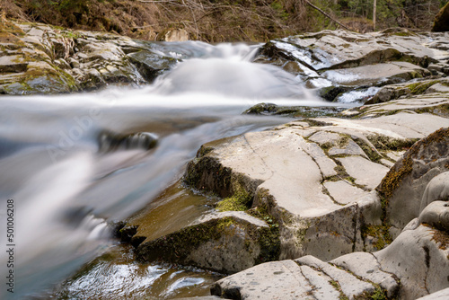 Mountain stream in spring in the stony forest. Beautiful river flowing by the forest during the Spring. Carpathian  Ukraine spring forest creek