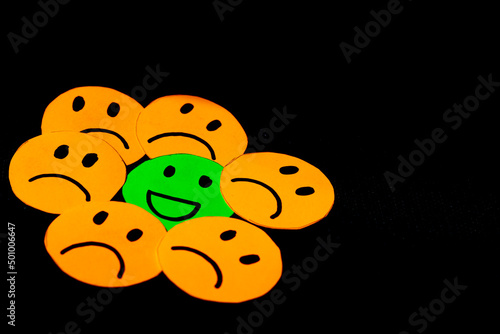 фотографія paper cutouts of sad smileys surrounding a happy smiley