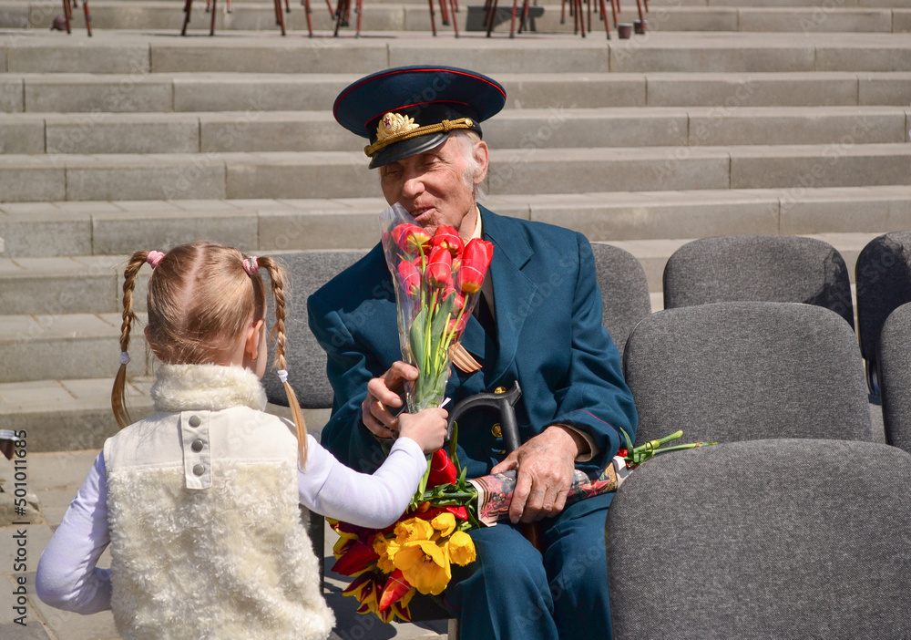 PYATIGORSK, RUSSIA - MAY 09, 2011: Girl gives flowers to veteran on Victory Day. - obrazy, fototapety, plakaty 