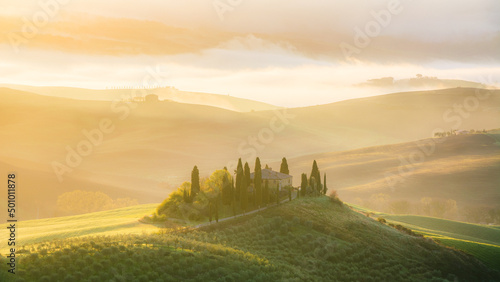 ITALY, TUSCANY, SAN QUIRICO D'ORCIA - Podere Belvedere farmhouse at sunrise with view of Val d'Orcia hills.