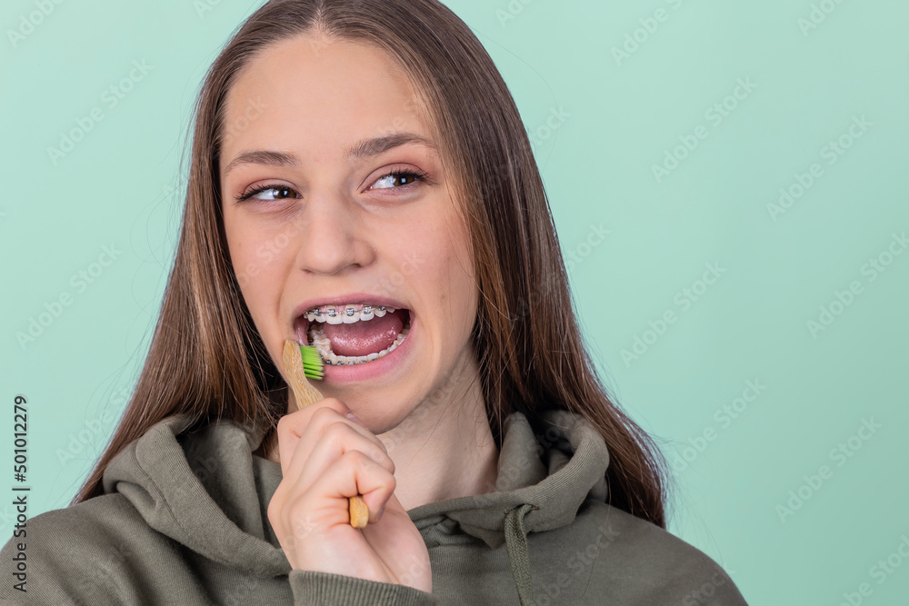 Portrait of young female with braces brushing teeth. Dental concept. Portrait of young female with braces brushing teeth. Dental concept.
