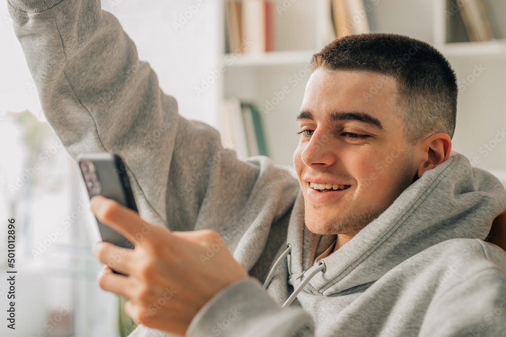 young man with mobile phone at home young man with mobile phone at home