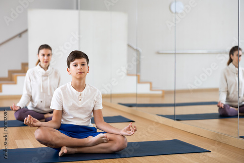 Teen boy exercising with sister, mother and father at yoga class, friendly family practicing self-care