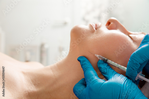 Cosmetologist performs the chin lift procedure by injecting beauty injections Fototapet