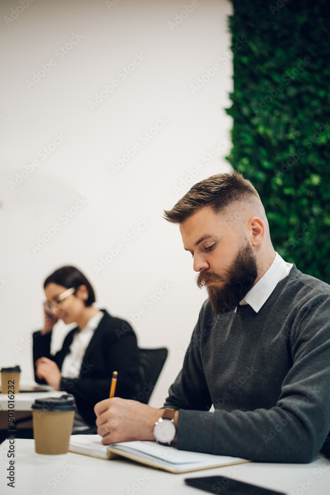 Handsome businessman sitting at his desk in the office Handsome businessman sitting at his desk in the office