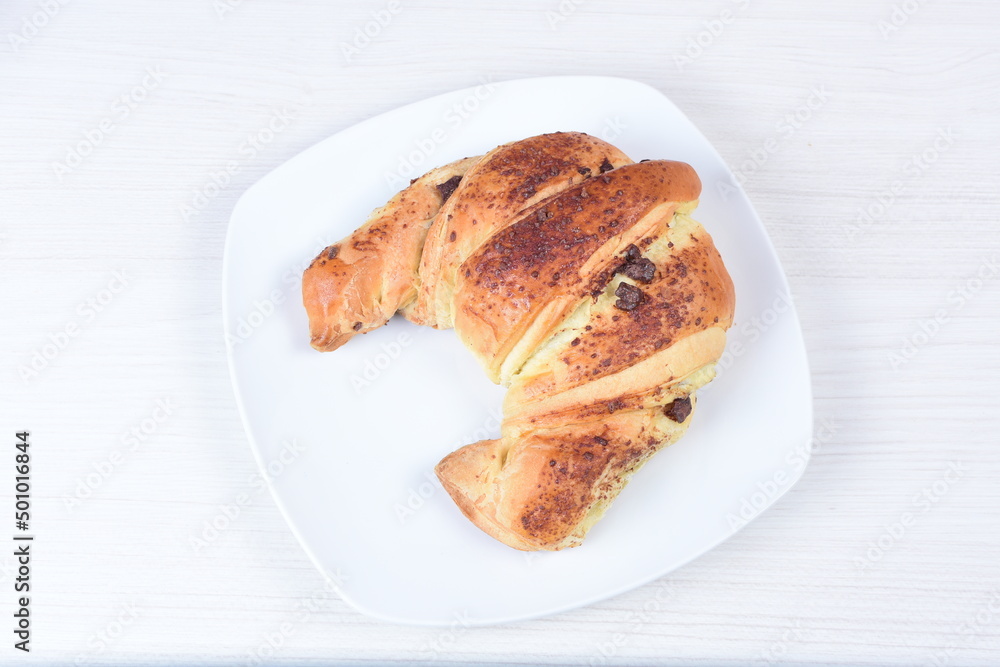 traditional croissant with melted cheese on wooden background