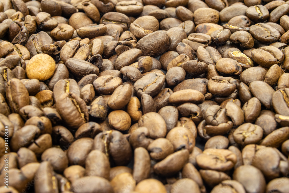 Coffee on black surface. Dense fresh roasted beans of Arabica Robusta. Low depth of field. Roasted coffee beans on black background. Beautiful beans arabica robusta. Perfect start of a day. Coffee on black surface. Dense fresh roasted beans of Arabica Robusta. Low depth of field. Roasted coffee beans on black background. Beautiful beans arabica robusta. Perfect start of a day.