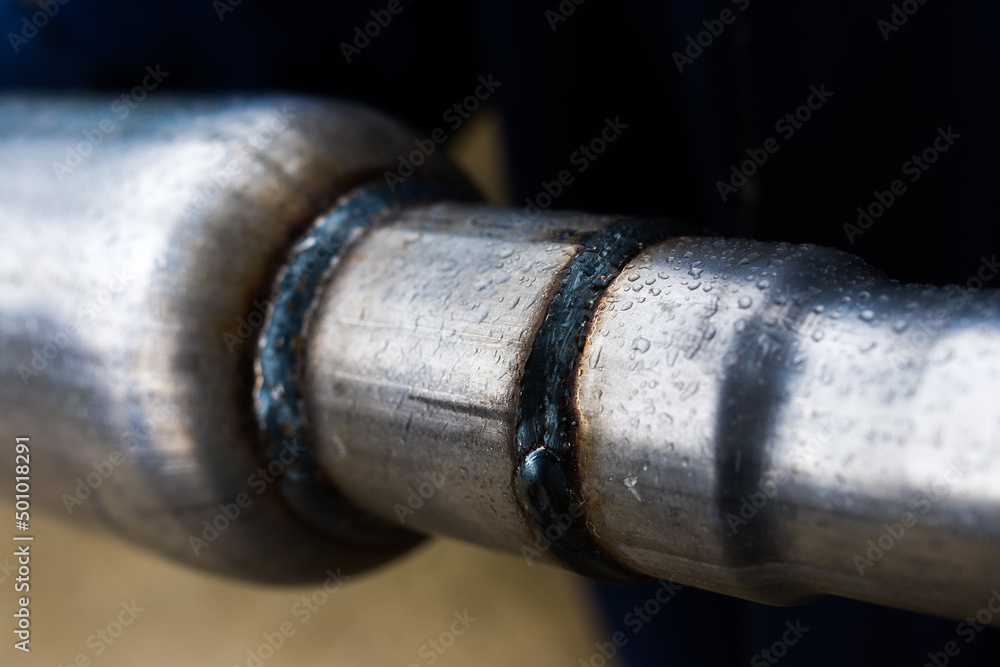 welding seam of a muffler for a car, close up welding seam of a muffler for a car, close up