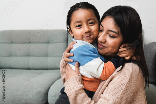 Happy Latin American mother and son hugging each other at home - Family love concept - Focus on child face photo