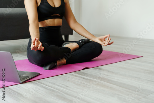 Attractive wellness Asian young woman sit on carpet breathing with yoga lotus pose, Yoga Exercise for Wellness Concept, Close up shot.