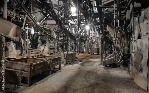 Interior of the old metallurgical plant. Stopped overhead conveyor with parts hooks
